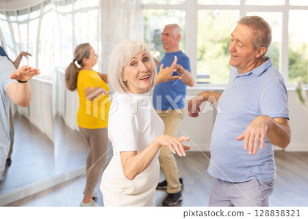Couple of elderly man and woman dancing twist 128838321