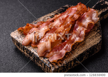 Cooked crispy bacon, slices of roast pork for an English breakfast. Fried bacon Cooked crispy bacon, slices of roast pork for an English breakfast. Fried bacon 128838400