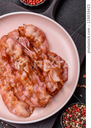 Cooked crispy bacon, slices of roast pork for an English breakfast. Fried bacon Cooked crispy bacon, slices of roast pork for an English breakfast. Fried bacon 128838425