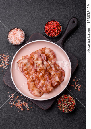 Cooked crispy bacon, slices of roast pork for an English breakfast. Fried bacon Cooked crispy bacon, slices of roast pork for an English breakfast. Fried bacon 128838429