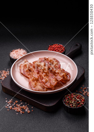 Cooked crispy bacon, slices of roast pork for an English breakfast. Fried bacon 128838430