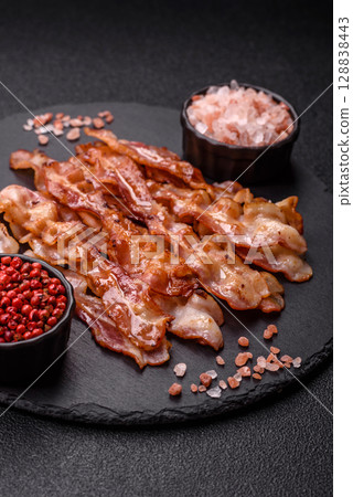 Cooked crispy bacon, slices of roast pork for an English breakfast. Fried bacon Cooked crispy bacon, slices of roast pork for an English breakfast. Fried bacon 128838443