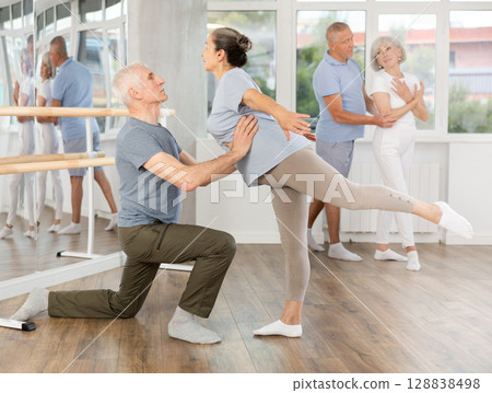 Mature man and woman practicing arabesque position of ballet in pair in dance studio 128838498