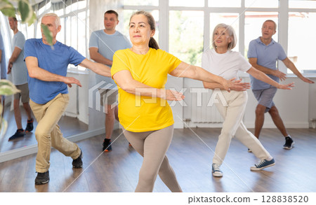 Portrait of active mature people enjoying modern energetic dancing in a group in studio 128838520