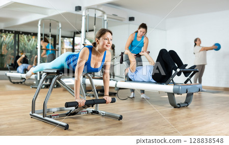 Woman doing exercises on wunda chair in pilates studio 128838548