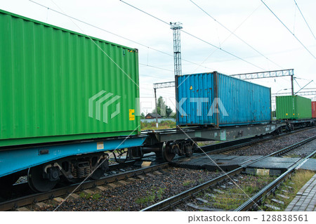 Freight train carrying colorful cargo containers on railway tracks 128838561