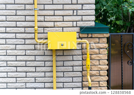 Yellow gas distribution box and pipes supplying a residential building 128838568