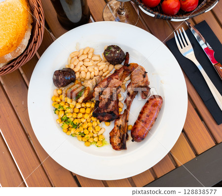 Lamb ribs on bone, sausage, piece of black pudding are complemented with stewed beans Lamb ribs on bone, sausage, piece of black pudding are complemented with stewed beans 128838577