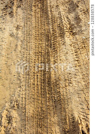 Tire tracks creating pattern on sandy ground 128838578
