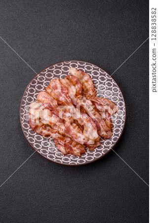 Cooked crispy bacon, slices of roast pork for an English breakfast. Fried bacon 128838582