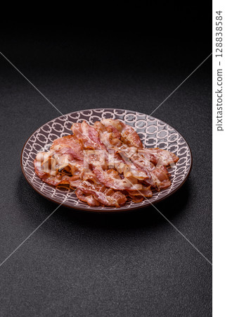 Cooked crispy bacon, slices of roast pork for an English breakfast. Fried bacon 128838584