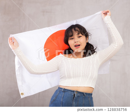 Smiling young girl holding Japan flag Smiling young girl holding Japan flag 128838756