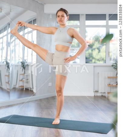 Young woman practicing yoga asanas in studio 128838884