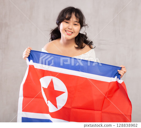 Smiling young girl holding North Korea flag Smiling young girl holding North Korea flag 128838902