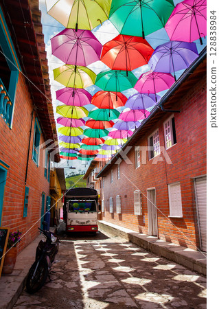 Truck parked at a beautiful street of the colonial town of Concepcion in Antioquia under colorful umbrellas in Colombia. 128838984