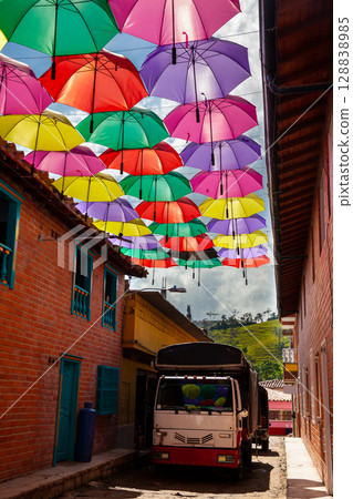 Truck parked at a beautiful street of the colonial town of Concepcion in Antioquia under colorful umbrellas in Colombia. Truck parked at a beautiful street of the colonial town of Concepcion in Antioquia under colorful umbrellas in Colombia. 128838985