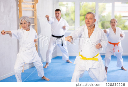 Senior students perform basic movements and repeat to hold pose, learning technique of kata 128839226