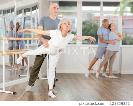 Mature man and woman practicing arabesque position of ballet in pair in dance studio 128839231