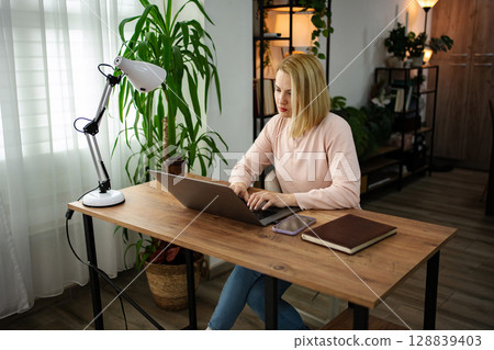 Working from home during the day brings focus and creativity in a cozy indoor workspace filled with greenery Working from home during the day brings focus and creativity in a cozy indoor workspace filled with greenery 128839403