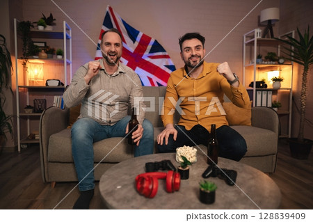 Friends enjoying a thrilling game night in a cozy living room with a British flair on a vibrant weekend evening 128839409