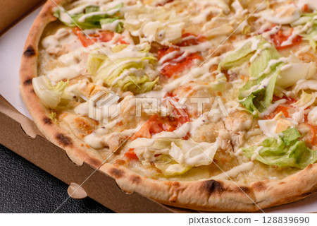 Italian caesar pizza with cheese and chicken, lettuce leaves and sauce 128839690