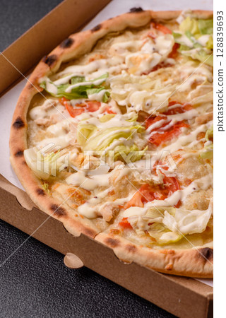 Italian caesar pizza with cheese and chicken, lettuce leaves and sauce 128839693