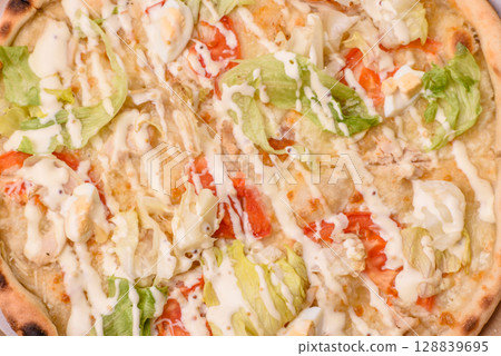 Italian caesar pizza with cheese and chicken, lettuce leaves and sauce 128839695