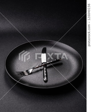 Empty plate with devices in the form of clock hands as a conceptual background for lunch time Empty plate with devices in the form of clock hands as a conceptual background for lunch time 128840156