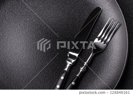 Empty plate with utensils as a conceptual background for lunch, breakfast, meal Empty plate with utensils as a conceptual background for lunch, breakfast, meal 128840161