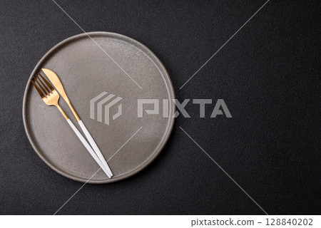 Empty plate with utensils as a conceptual background for lunch, breakfast, meal Empty plate with utensils as a conceptual background for lunch, breakfast, meal 128840202