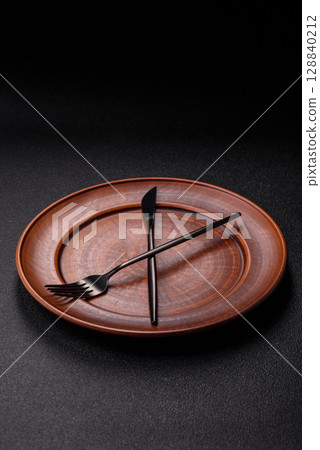 Empty plate with devices in the form of clock hands as a conceptual background for lunch time Empty plate with devices in the form of clock hands as a conceptual background for lunch time 128840212