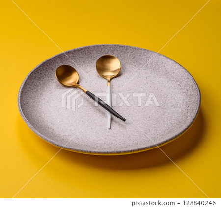 Empty plate with devices in the form of clock hands as a conceptual background for lunch time 128840246