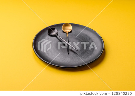 Empty plate with devices in the form of clock hands as a conceptual background for lunch time Empty plate with devices in the form of clock hands as a conceptual background for lunch time 128840250