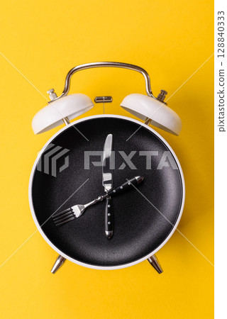 Empty plate with devices in the form of clock hands as a conceptual background for lunch time Empty plate with devices in the form of clock hands as a conceptual background for lunch time 128840333