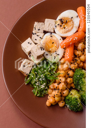 Vegan salad, bowls with chickpeas, broccoli, tomatoes, tofu cheese and boiled eggs Vegan salad, bowls with chickpeas, broccoli, tomatoes, tofu cheese and boiled eggs 128840504