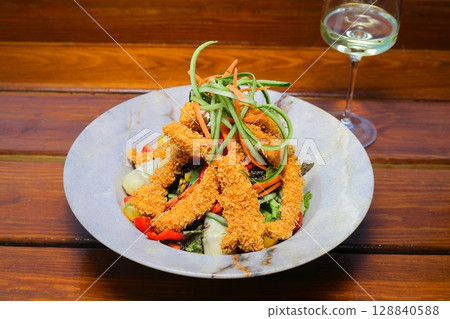 Salad with grilled chicken breast. Fresh vegetable salad with chicken wings meat Salad with grilled chicken breast. Fresh vegetable salad with chicken wings meat 128840588