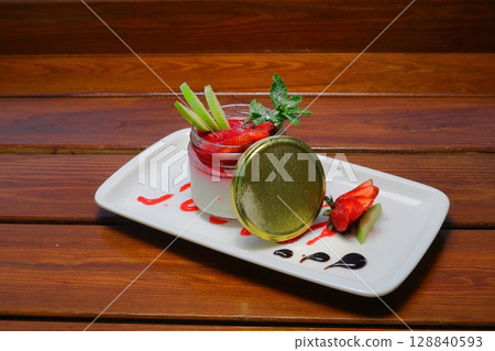 Delicious panna cotta with strawberry coulis and fresh berries on wooden background 128840593
