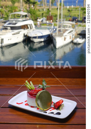 Delicious panna cotta with strawberry coulis and fresh berries on wooden background 128840594