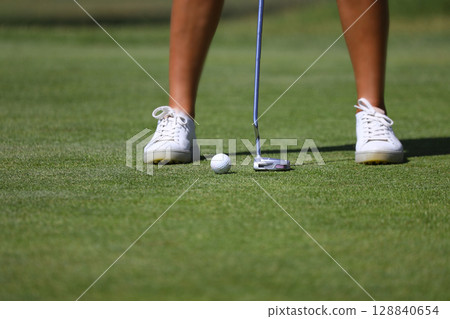 Golfer playing golf in the evening golf course, on sun set evening time, Man playing golf on a golf course in the sun. Golfer playing golf in the evening golf course, on sun set evening time, Man playing golf on a golf course in the sun. 128840654