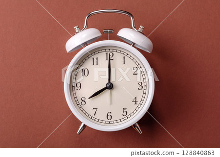 Vintage alarm clock on brown surface as a conceptual background for deadlines for tasks 128840863