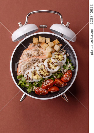 Caesar salad with chicken, croutons, tomatoes and eggs with seeds and grains 128840938