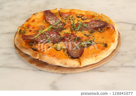 assorted pizza with different fillings: salami, tomatoes, mushrooms, bacon, sun-dried tomatoes 128841077