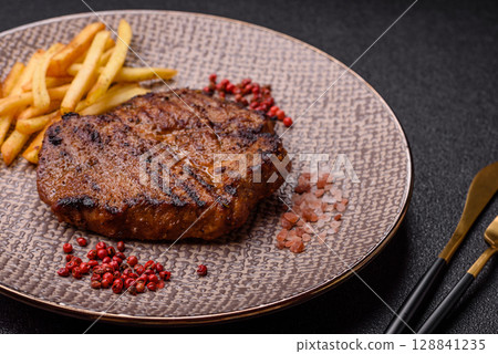 Meat, steak, beef tenderloin cooked on grill. Juicy steak as a food background 128841235