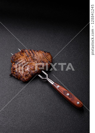 Meat, steak, beef tenderloin cooked on grill. Juicy steak as a food background 128841245