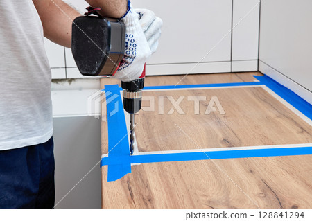 repairman using electric drill and installation new modern kitchen repairman using electric drill and installation new modern kitchen 128841294