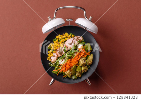 Salad with chicken, tomatoes and eggs with seeds and grains. Concept time to eat dinner 128841328