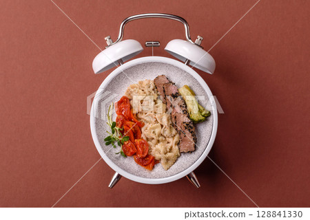 Italian pasta with meat, sauce and vegetables. Conceptual background time to eat pasta 128841330