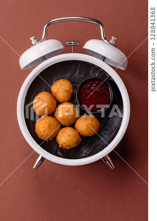 Cheese balls, croquettes fried, breaded fast food with sauce. Concept of time to eat fast food Cheese balls, croquettes fried, breaded fast food with sauce. Concept of time to eat fast food 128841368