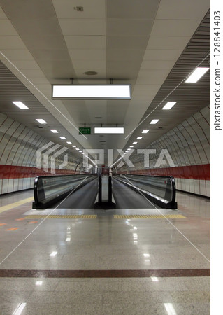 moving escalator in subway station. Walkway with Blank billboard located in underground hall or subway for advertising, mockup concept, moving escalator in subway station. Walkway with Blank billboard located in underground hall or subway for advertising, mockup concept, 128841403