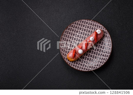 French food, dessert eclair with chocolate filling. Eclair as a background French food, dessert eclair with chocolate filling. Eclair as a background 128841506